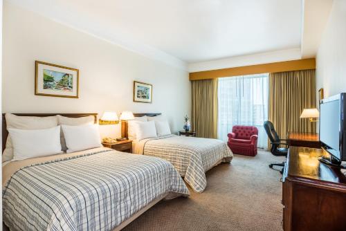 巴拿马城Hospedium Princess Hotel Panamá的酒店客房设有两张床和电视。