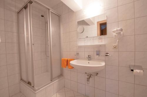 耶岑斯阿尔彭弗雷德酒店的白色的浴室设有水槽和淋浴。