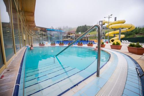 奥拉维斯MEANDER THERMAL & SKI REZORT ORAVICE的大楼内一个带滑梯的游泳池