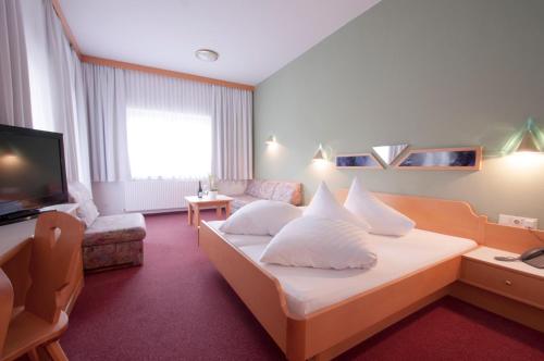 耶岑斯阿尔彭弗雷德酒店的酒店客房,配有床和电视