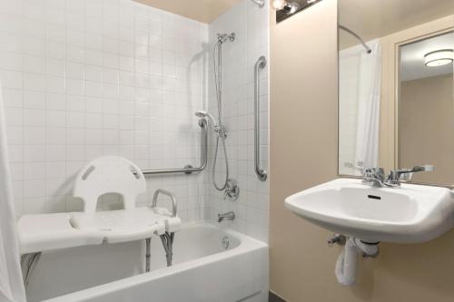 斯蒂芬维尔斯蒂芬维尔戴斯酒店的白色的浴室设有水槽和浴缸。