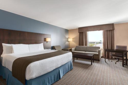 斯蒂芬维尔斯蒂芬维尔戴斯酒店的配有一张床和一张书桌的酒店客房