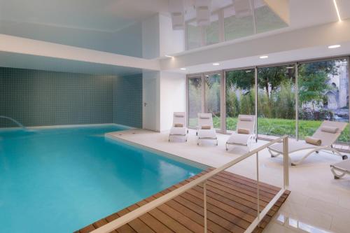 卡奥尔迪沃纳卡奥尔贝斯特韦斯特PLUS酒店的一个带白色椅子的游泳池