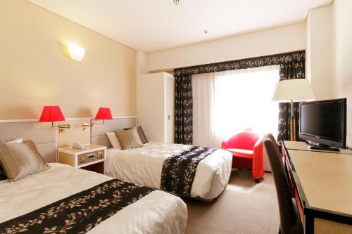 福岛吨详福岛旅馆的酒店客房设有两张床和电视。