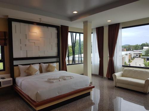 Thung Song微笑同松度假酒店的一间卧室配有一张床、一把椅子和窗户。