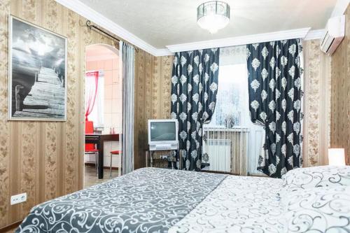 扎波罗热Apartment on Nezalezhnoy Ukrаiny near Intourist Hotel的一间卧室配有一张床和一台电视