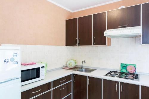 扎波罗热Apartment in Zaporozhye. Antica的厨房配有棕色橱柜、水槽和微波炉