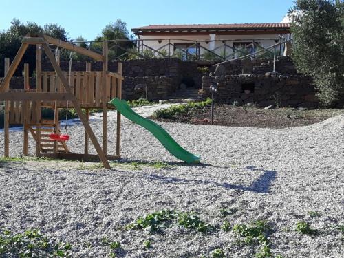 卡拉古诺内Agriturismo Su Barcu的一个带绿色滑梯的沙地游乐场