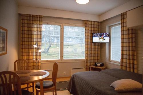 萨利色尔卡劳图拉皮公寓的一间卧室配有一张床、一张桌子和一台电视