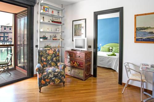 热那亚Sull'Acqua del Porto Antico的一间带椅子和电视的客厅以及一间卧室