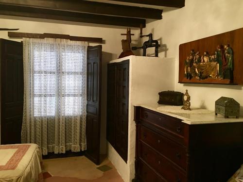 阿尔卡拉斯Casa Rural Bracamonte的一间卧室配有一张床、一个梳妆台和一扇窗户。