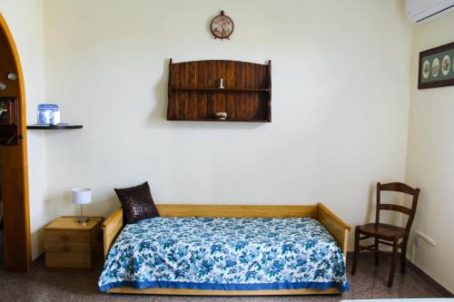 阿沃拉Casa Sanfaso'的卧室配有一张床,墙上挂着一个钟