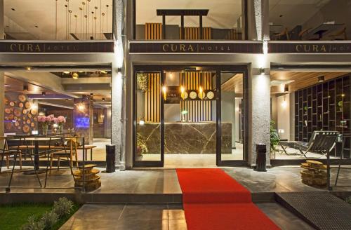 恰纳卡莱库拉酒店的酒店大堂铺有红地毯,配有桌子