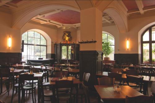 慕尼黑马里兰德酒店的一间设有桌椅的餐厅,位于带窗户的房间内