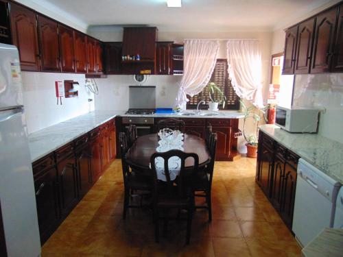 Faja GrandeCasa da Sogra的厨房配有木制橱柜和桌椅