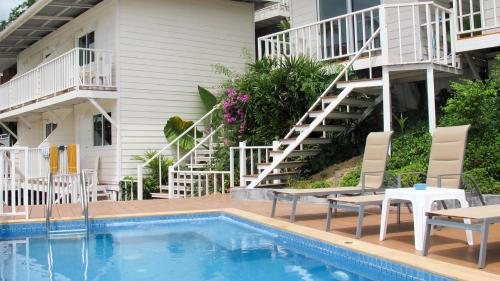 皮皮岛上坡村舍酒店的一座设有游泳池、椅子和楼梯的酒店