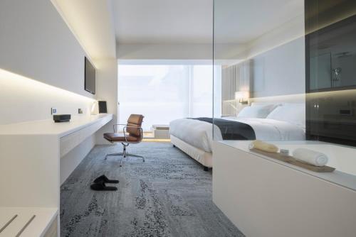 台北二十轮旅店大安馆的一间卧室配有两张床、一张桌子和一把椅子