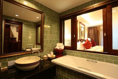 清迈瓦昂鲁昂度假村的一间带大浴缸和两面镜子的浴室