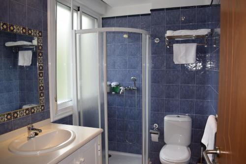 桑亨霍Apartamentos VIDA Sanxenxo的蓝色瓷砖浴室设有卫生间和水槽