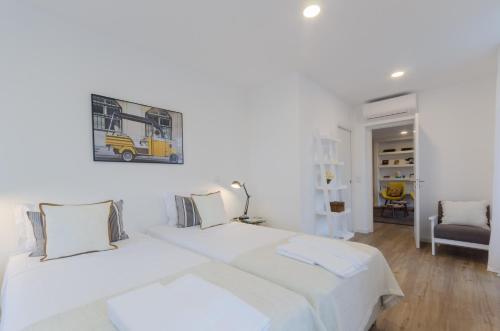 里斯本洛格公寓的白色卧室配有一张带白色床单的大床