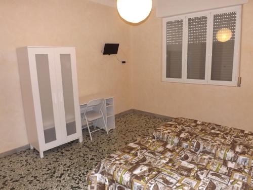 塔兰托Bed And Breakfast Il Subacqueo的一间卧室配有一张床、一张书桌和一个窗户。