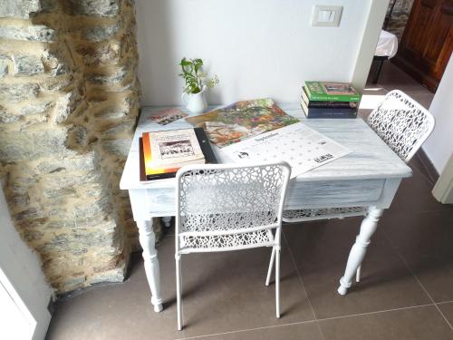 CarbutaCa Du Ventu的一张带两把椅子的白色桌子和一本书