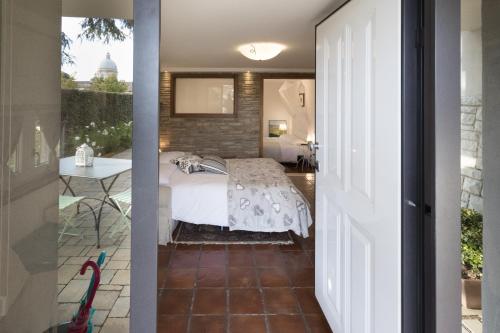 阿西西阿西西迷人住宿加早餐旅馆的卧室设有一张床和一个阳台,享有风景。