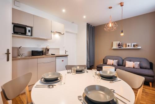 里昂Studios Part-Dieu Gare - HomaLyon的厨房以及带白色桌椅的起居室。