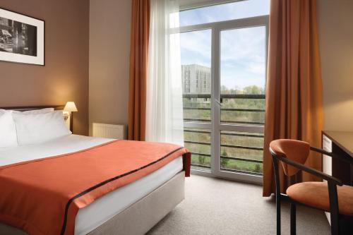 利沃夫利沃夫华美达酒店的酒店客房设有一张床和一个大窗户