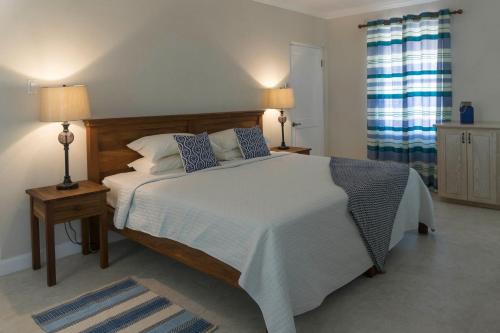 布里奇敦桑盖特旅馆的一间卧室配有一张大床、两盏灯和两张桌子
