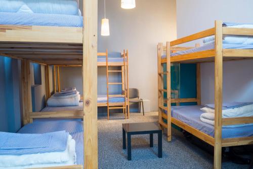 罗兹GO Hostel Rewolucji的客房设有三张双层床和一张桌子。