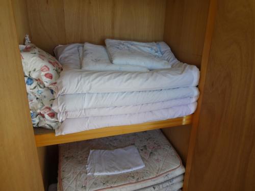 宫古岛Pension Orange Box的衣柜架上的毛巾堆