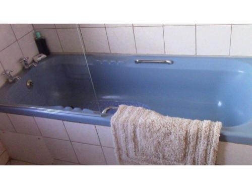 斯托姆勒菲Forest Nest的浴室设有蓝色浴缸,配有毛巾