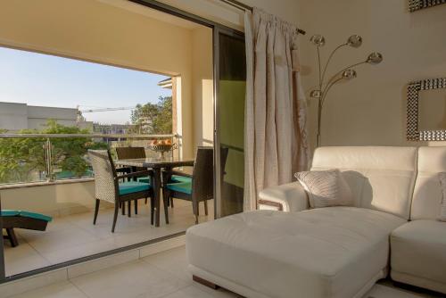 内罗毕地标套房公寓的客厅配有白色的沙发、桌子和椅子