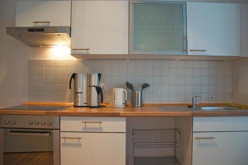 柏林Linnen Luxx Apartment的厨房配有白色橱柜和木制台面