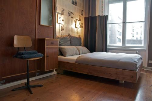 柏林Linnen Luxx Apartment的卧室配有床、椅子和窗户。