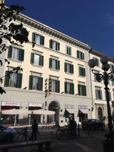 佛罗伦萨卡拉瓦乔酒店的一座白色的大建筑,设有绿色百叶窗