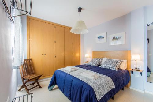 加的斯Apartamento PUERTA-CALETA by Cadiz4Rentals的一间卧室配有蓝色的床和木制橱柜