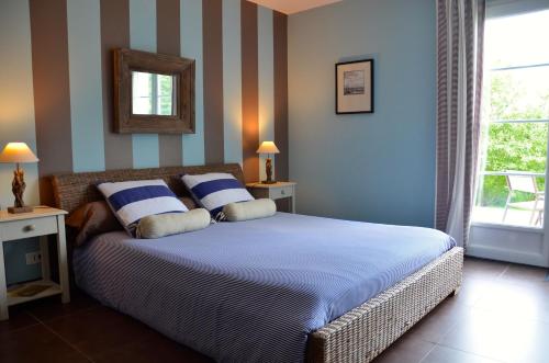 Belle-et-Houllefort佳丽别墅酒店的一间卧室设有一张带条纹墙壁的床和窗户。