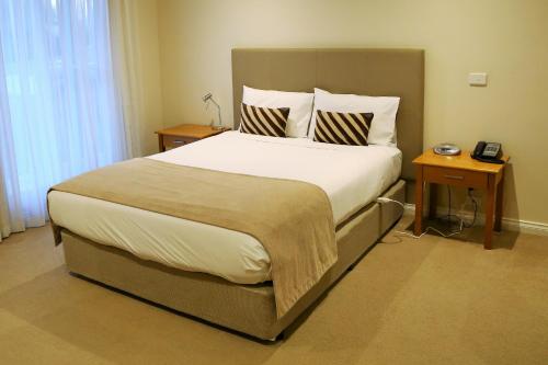 Allansford艾尔兰福德汽车旅馆的一间卧室配有一张带2个床头柜的大床