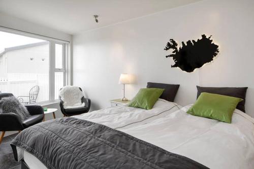 凯夫拉维克海景公寓别墅的一间卧室配有一张带绿色枕头的大床