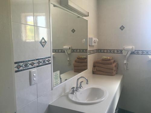 达博亚伯塔斯曼汽车旅馆 的白色的浴室设有水槽和镜子