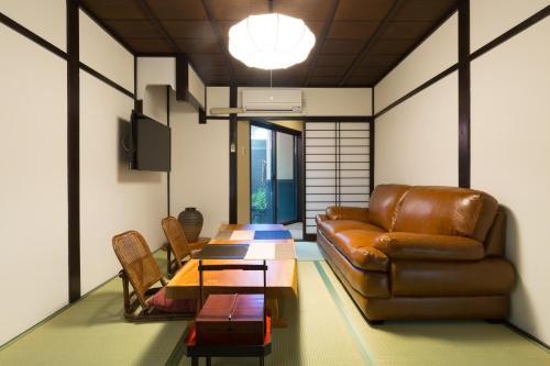 京都京都苏扎库安度假屋的客厅配有真皮沙发和桌子