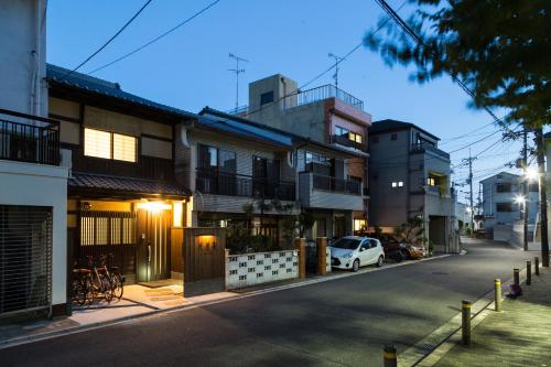 京都京都苏扎库安度假屋的一条有白色汽车停在楼前的街道