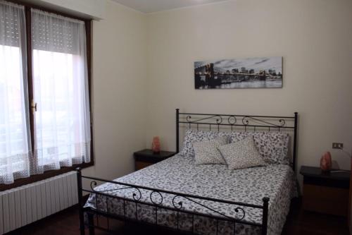 纳维廖河畔特雷扎诺Appartamento Le Magnolie的一间卧室设有一张床和两个窗户。