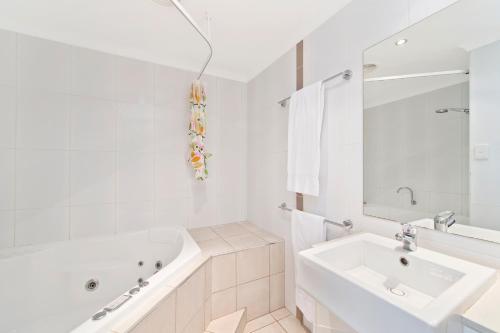 麦夸里港Beach Resort Apartment的白色的浴室设有浴缸和水槽。