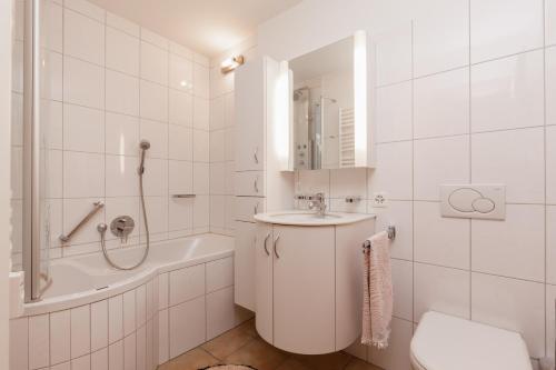 Sankt Moritz-BadChesa Derby 3的白色的浴室设有水槽、浴缸和卫生间。