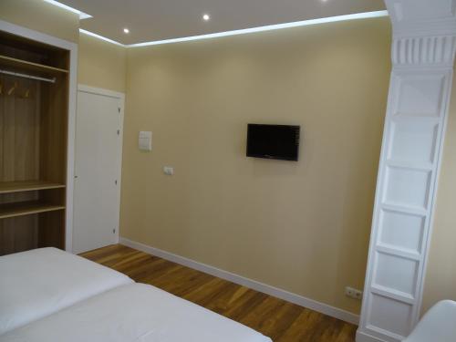 布尔戈斯Urban Burgos的卧室配有一张床,墙上配有电视