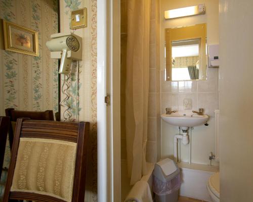 埃文河畔斯特拉特福蒙莱克尔酒店的一间带水槽和镜子的小浴室