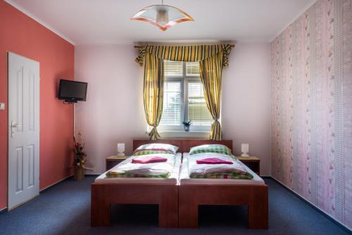 捷克利帕Penzion Na Kopečku的一间卧室设有一张红色墙壁和窗户的床
